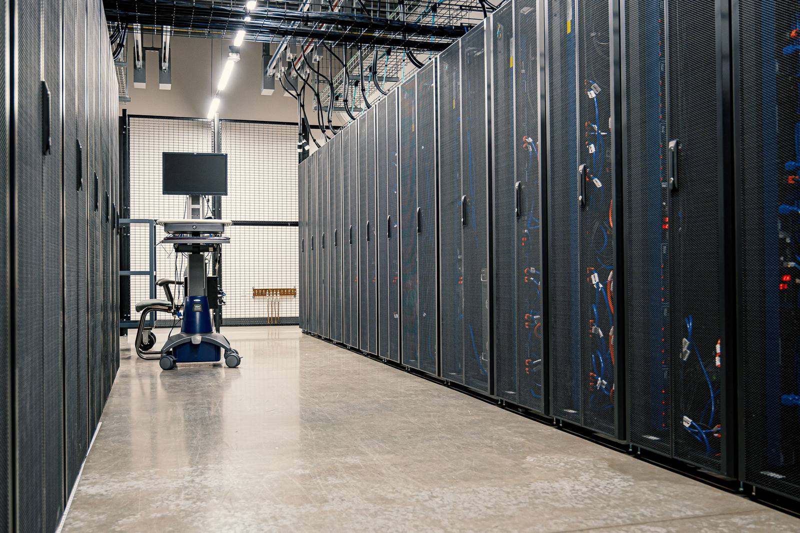 Técnico trabajando entre racks de servidores en un centro de datos