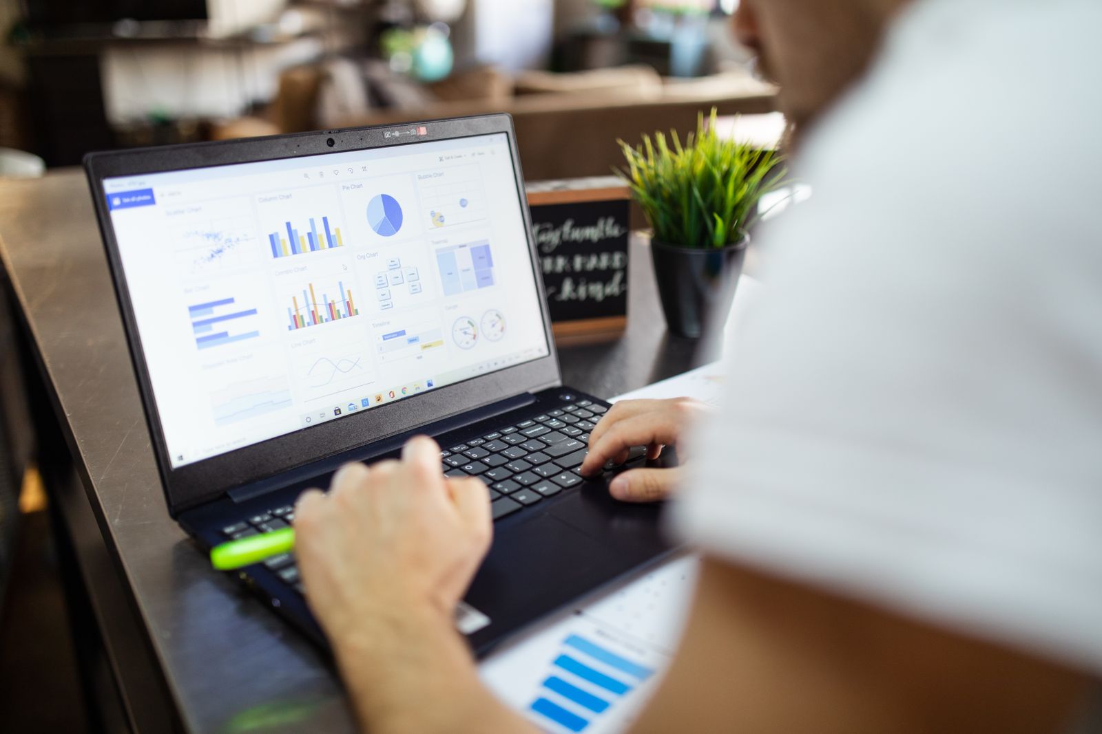 Analista construyendo gráficas y tableros de datos en un portátil
